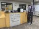 A whiteboard attached to a wooden desk reads, “Check Handshake for On-Campus Jobs, Jobs, Internships, and Events! albion.edu/handshake.” A mannequin wearing gray slacks, a purple-and-white-striped shirt and a gray tie stands to the right of the desk.