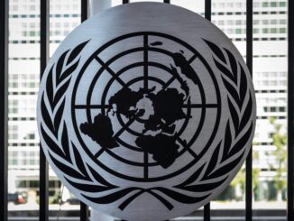 The Model United Nations logo is on a silver circle with a city in the background. The logo itself has a map of the world with olive branches surrounding it.