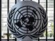 The Model United Nations logo is on a silver circle with a city in the background. The logo itself has a map of the world with olive branches surrounding it.